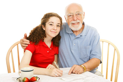 teenage girl doing paperword with her grandfather