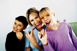 Mother, son, and duaghter brushing their teeth