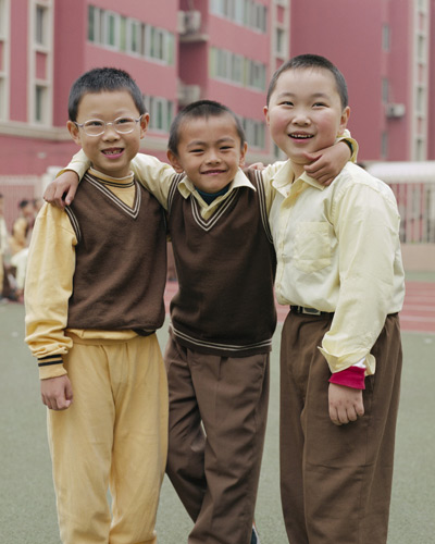 three boys standing in front of an apartment building