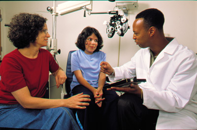 mother and daughter talking with the opthalmologist (eye doctor)