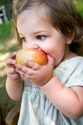 young girl eating an apple