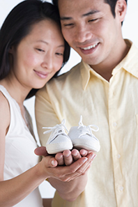 couple holding baby shoes