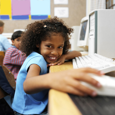 girls sitting in front of a computer